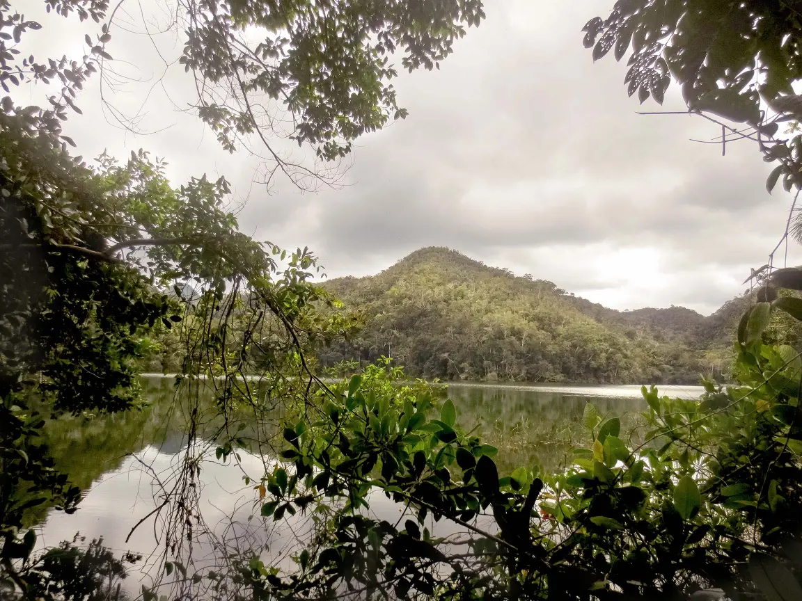 Unexplored remote lake framed by rainforest canopy and mountain ridges in Sierra del Divisor National Park